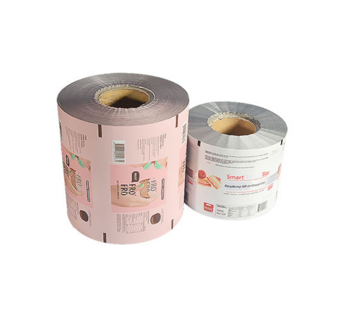 Two rolls of printed food packaging film on white background. The larger roll on the left is pink with graphics of hands holding ice cream cones and text. The smaller roll on the right is white with graphics of a cake slice and text.