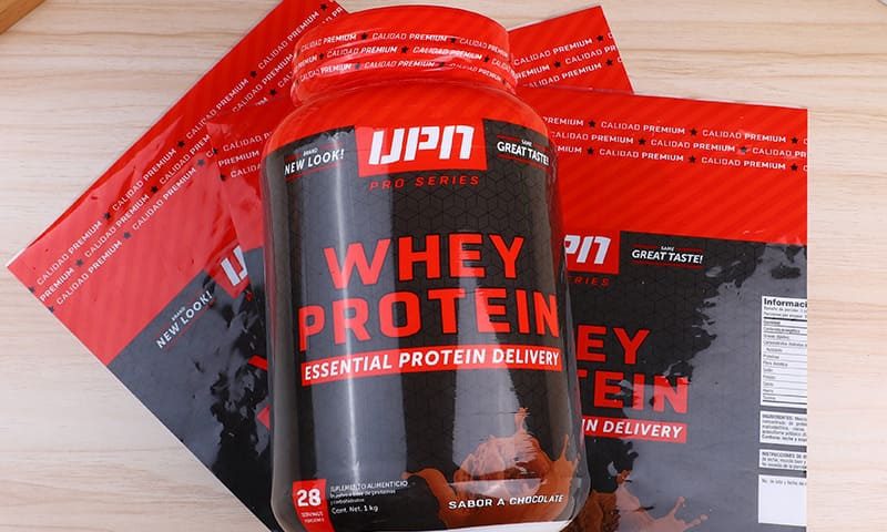 The image shows a stack of three red and black bags of protein powder, each featuring the brand logo "JPN" in white, with the product