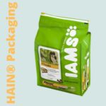 A bright green bag of dog food with a white resealable closure at the top. The front features a label with a picture of a dog, text indicating 'Chunks', and the brand logo 'IAMS' in large white letters with paw prints.