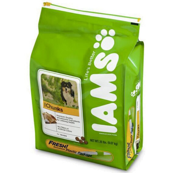 A bright green bag of dog food with the brand name "IAMS" prominently displayed vertically in large white letters with paw prints. A picture of a dog is on the left side, along with text about the product. The bag has a resealable plastic closure at the top.