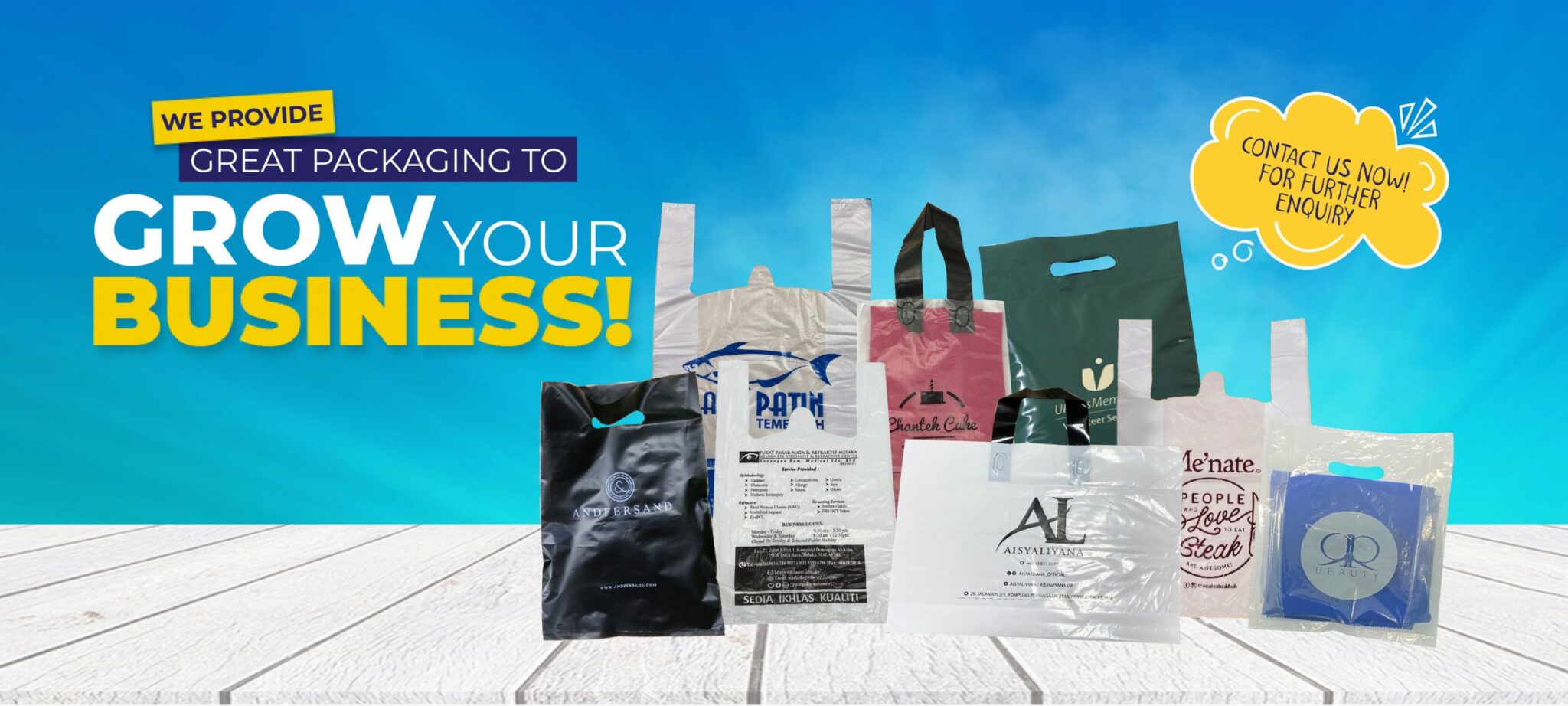 A collection of various plastic shopping bags with handles, displaying different colors, graphics, and printed text, arranged on a wooden surface against a blue sky background.