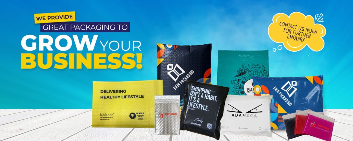 A collection of various padded and unpadded mailers, some with bubble wrap texture, displayed on a white wooden surface against a blue gradient background. Text includes promotional messages and brand names.