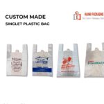 Four white singlet plastic bags with handles, each featuring different custom printing. The first bag has a brown graphic and text. The second bag has a blue fish graphic and text. The third bag has red graphics and text. The fourth bag has green text.