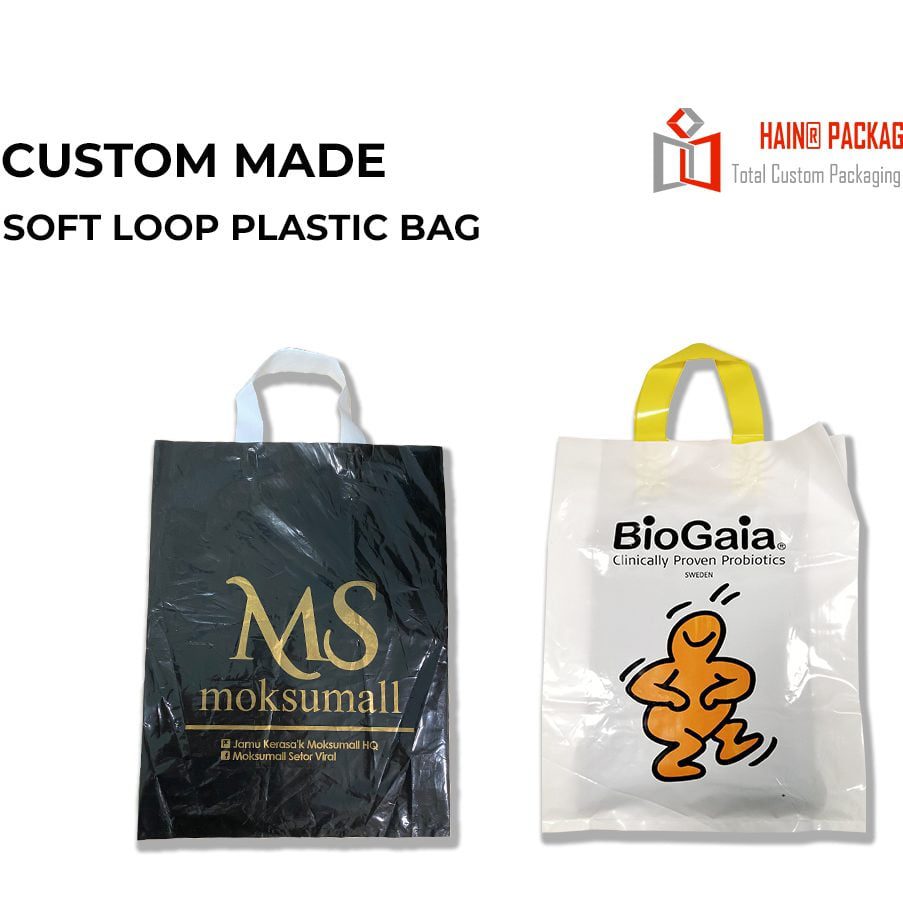 Two custom soft loop plastic bags, one black with gold print and one translucent with yellow print, a clear handle plastic bags handle type in service