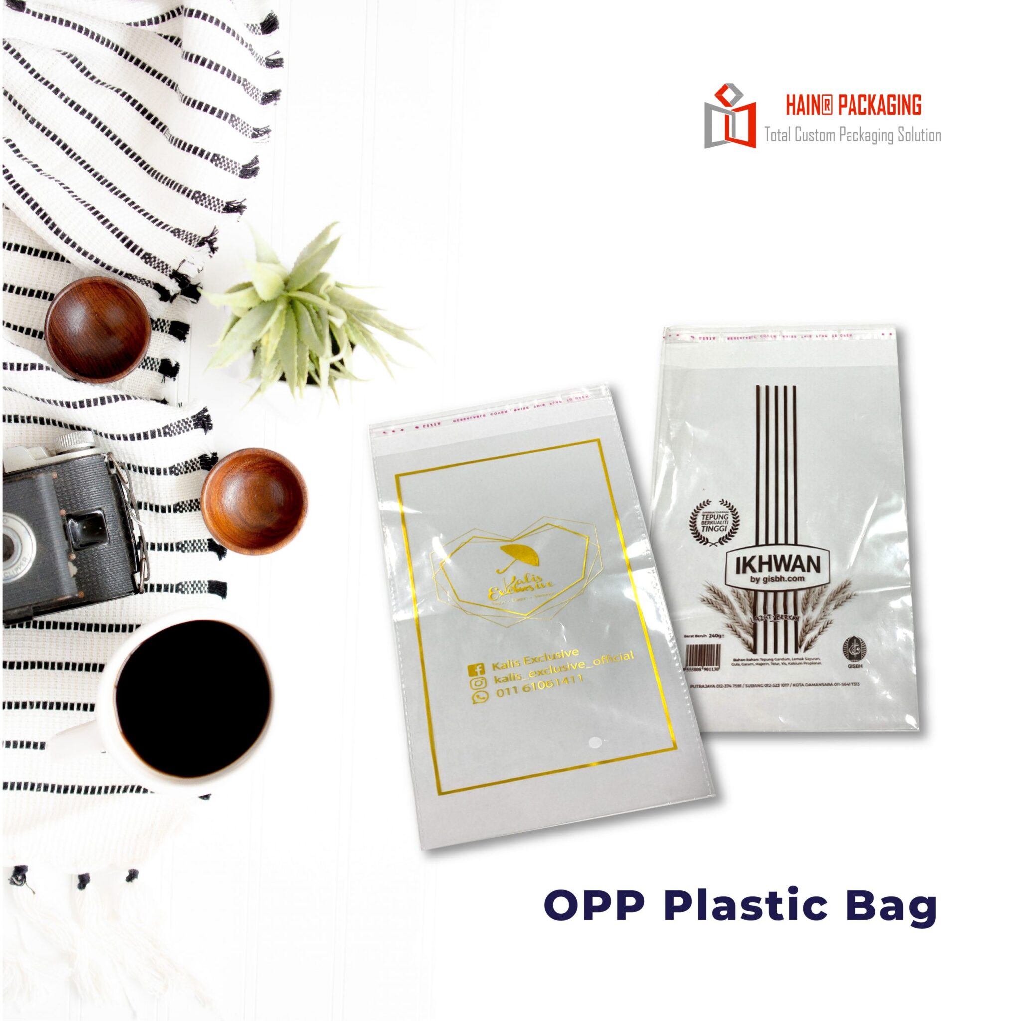 Two clear plastic bags with printed graphics and text, one with a gold geometric design and the other with vertical brown lines and wheat stalks. Both bags have a sealed top edge.