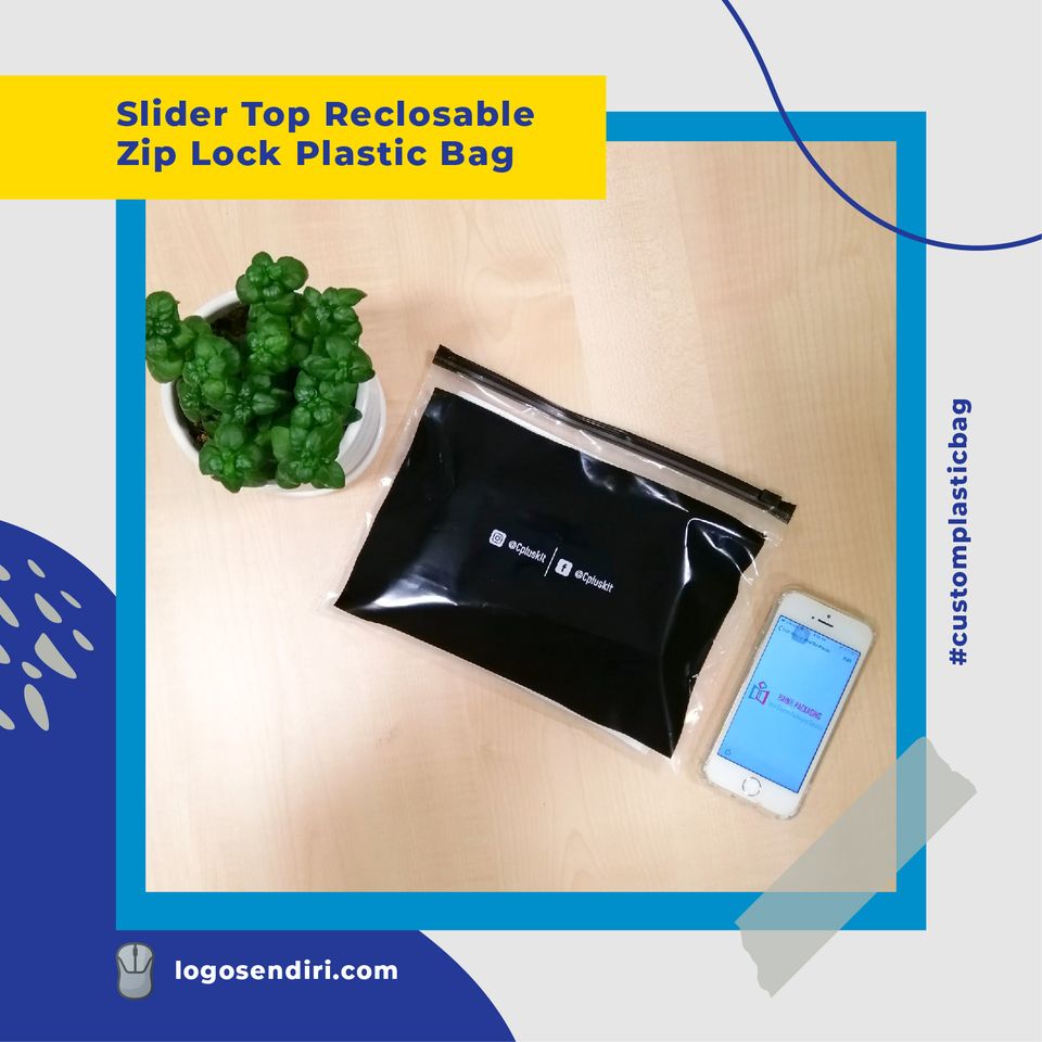 A black slider top reclosable bag shown on a wooden surface beside a potted plant