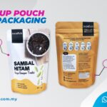 Two stand-up pouches are displayed. The left pouch is white with black text and a picture of food. The right pouch is golden brown with nutritional information and ingredients listed. A pink oval highlights 'Matte' and another highlights '16 x 11cm'.