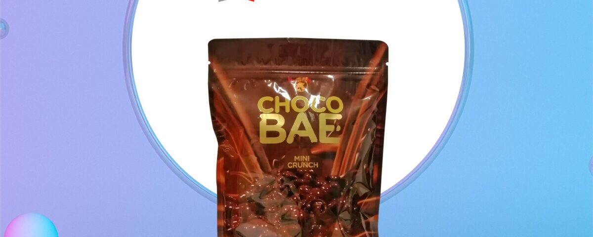 A brown stand-up pouch bag with a glossy finish, featuring a graphic of chocolate and text that reads 'CHOCO BAE MINI CRUNCH' and 'HAN'S SECRET PREMIUM CHOCOLATE 430g'. The bag is displayed on a light blue podium against a gradient background.