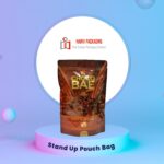 A brown stand-up pouch bag with a glossy finish, featuring a graphic of chocolate and text that reads 'CHOCO BAE MINI CRUNCH' and 'HAN'S SECRET PREMIUM CHOCOLATE 430g'. The bag is displayed on a light blue podium against a gradient background.