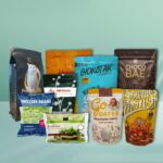 A collection of various stand-up pouches and bags for food products, including cat food, frozen beans, edamame, cookies, dates, and brownies, displayed against a light blue background.