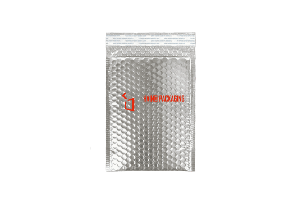 A silver padded mailer envelope with a bubble-lined interior and a peel-off adhesive strip along the top opening. The envelope features a logo and text reading 'HAINER PACKAGING' and 'Custom Packaging Solutions'.