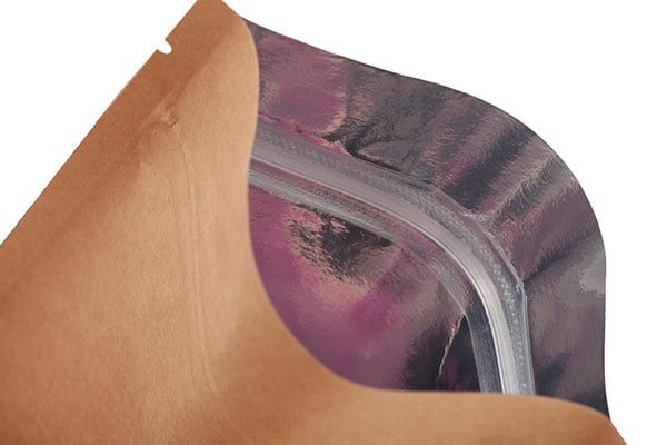A close-up of a resealable pouch, showing the brown exterior and the shiny, metallic purple interior with a clear zipper closure.